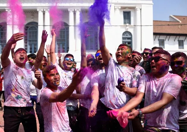 People throw coloured powder as they celebrate Holi, the Festival of Colours in Kathmandu, Nepal on March 06, 2023. (Photo by Monika Malla/Reuters)