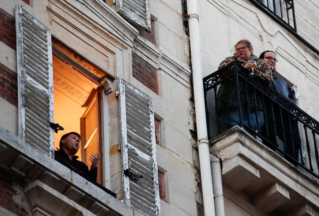 French tenor singer Stephane Senechal sings from his apartment window in Paris as a lockdown is imposed to slow the rate of the coronavirus disease (COVID-19) spread in France, March 24, 2020. (Photo by Gonzalo Fuentes/Reuters)