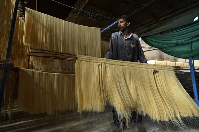 A worker prepares traditional vermicelli noodles, a favorite during the Muslim holy fasting month of Ramadan, at a factory, in Karachi, Pakistan, Monday, April 10, 2023. (Photo by Fareed Khan/AP Photo)