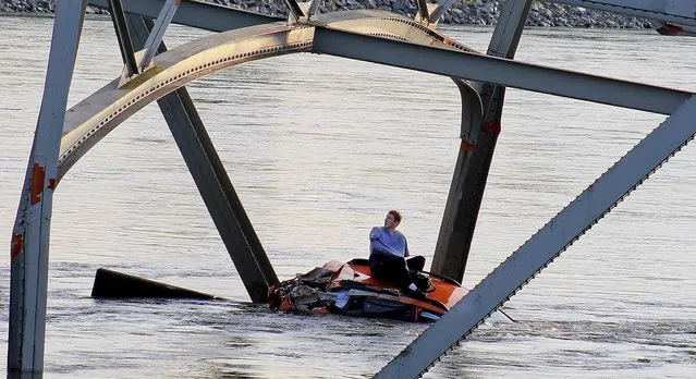 A man waits to be rescued after his car fell into the Skagit River after the collapse of the Interstate 5 bridge  in Mount Vernon, Wash, on May 23, 2013. (Photo by Francisco Rodriguez/Associated Press)