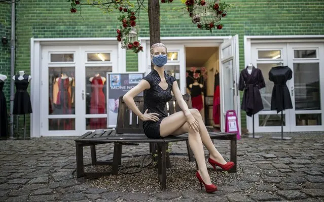 A store mannequin with a protective mask stands before a clothes store as they open for the first time since March during the novel coronavirus (COVID-19) pandemic on April 22, 2020 in Berlin, Germany. Small to midsized-shops are opening across Germany this week as state authorities follow a recommendation by the federal government to ease restrictions imposed in March meant to slow the spread of the coronavirus. Some schools are also planning to reopen soon, as are museums and hair salons in coming weeks. (Photo by Maja Hitij/Getty Images)