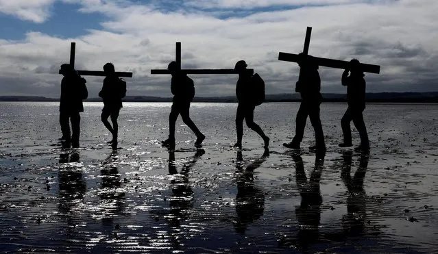 Pilgrims celebrate Easter as they walk over the tidal causeway to Lindisfarne during the final leg of their Good Friday pilgrimage in Berwick-upon-Tweed, Northumberland, Britain on April 7, 2023. (Photo by Lee Smith/Reuters)