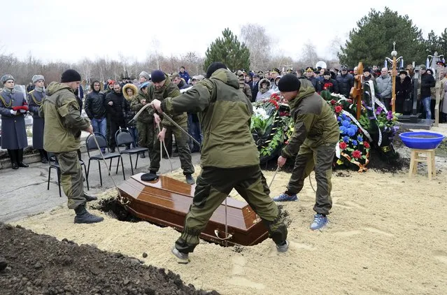 Men lower the coffin into the ground during the funeral of Alexander Pozynich, a Russian marine killed during an operation to recover the crew of the downed Su-24 jet, at a cemetery in Novocherkassk, Rostov region, Russia, November 27, 2015. (Photo by Sergey Pivovarov/Reuters)