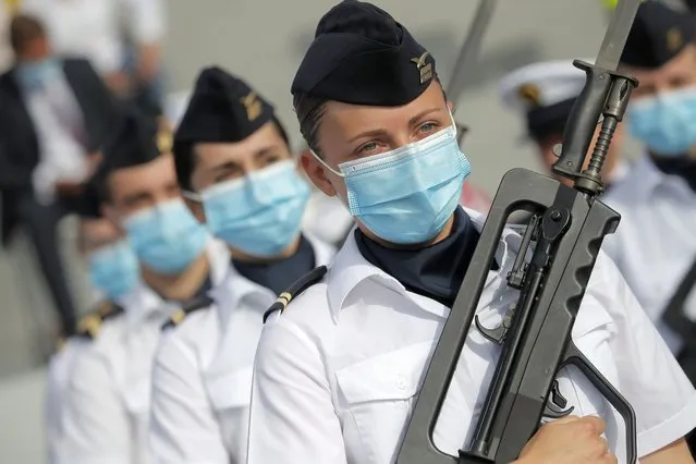 Soldier wear face masks prior to the Bastille Day parade Tuesday, July 14, 2020 on the Champs Elysees avenue in Paris. France are honoring nurses, ambulance drivers, supermarket cashiers and others on its biggest national holiday Tuesday. Bastille Day's usual grandiose military parade in Paris is being redesigned this year to celebrate heroes of the coronavirus pandemic. (Photo by Christophe Ena/AP Photo/Pool)