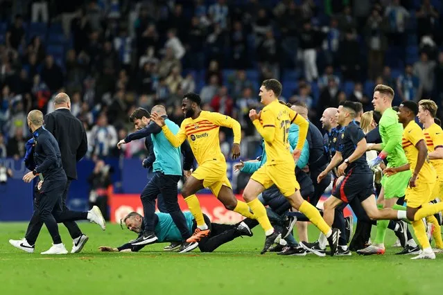 Players and staff of FC Barcelona attempt to leave the pitch as fans of RCD Espanyol attempt to pitch invade after the LaLiga Santander match between RCD Espanyol and FC Barcelona at RCDE Stadium on May 14, 2023 in Barcelona, Spain. (Photo by David Ramos/Getty Images)