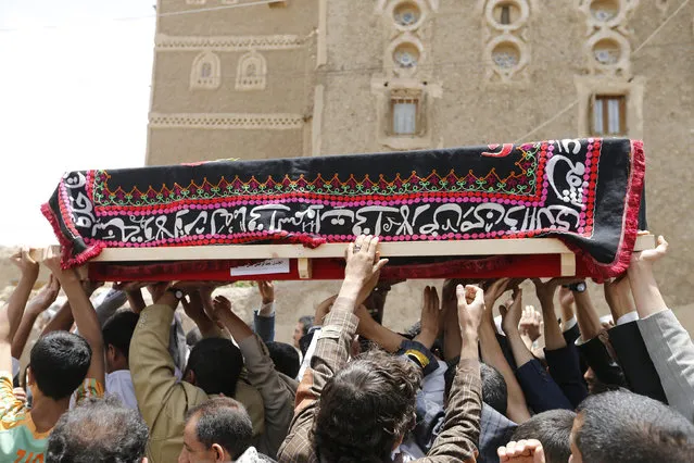 Mourners carry the coffin of a soldier, who was killed by al Qaeda militants in the Wadi Hadramout region in northeastern Yemen, during his funeral in Sanaa August 10, 2014. (Photo by Khaled Abdullah/Reuters)