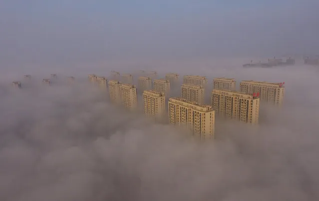 Buildings shrouded in fog in east China’s Shandong province on November 14, 2016. The National Meteorological Centre issued an orange warning for heavy fog in the area. (Photo by Xinhua/Barcroft Images)