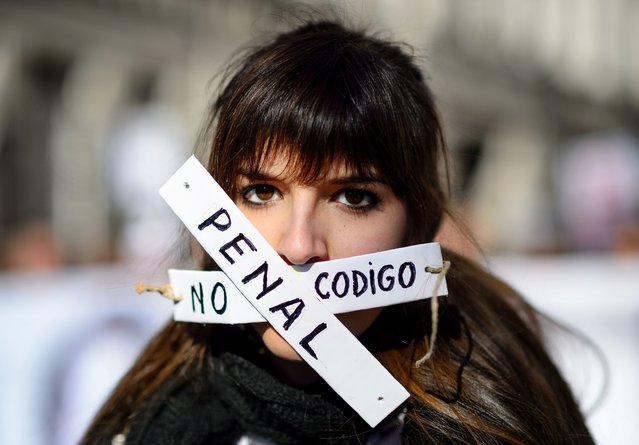 A woman covers her mouth with strips that read “no penal code” as she takes part in a demonstration called by the “Dignity Marches” platform against the new public security law, dubbed “ley mordaza” (gag law), in Madrid on January 25, 2015. The lower house of Spanish parliament passed this law, on December 12, 2014, with the only affirmative votes of the ruling Popular Party (PP). (Photo by Dani Pozo/AFP Photo)