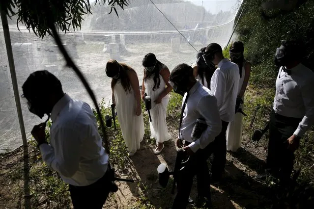 Israeli couples attend a “trash the dress” event at a paint-ball venue in the southern Israeli city of Ashdod, December 25, 2015. (Photo by Amir Cohen/Reuters)