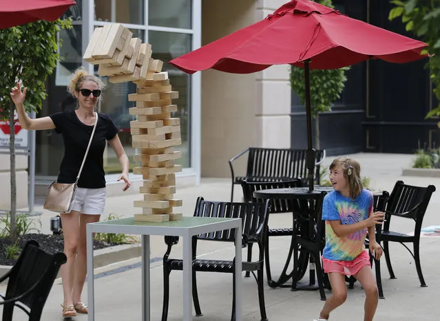 Veneta Bodurova, left, and her daughter Emma, from Delaware, Ohio, play a game of giant Jenga during the grand opening of The Yard at Polaris Fashion Place Sunday, July 15, 2018 in Columbus, Ohio. The Yard is Polaris Fashion Place's newest community gathering place where people can enjoy outdoor games while shopping and dining. (Photo by Jay LaPrete/AP Images for Washington Prime Group)