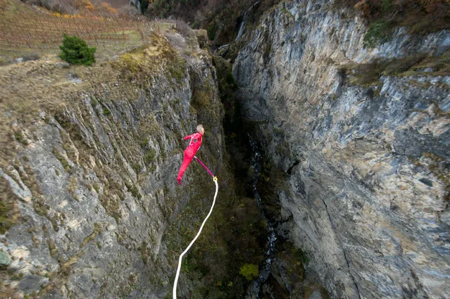 French bungee jump acrobate Thierry Devaux jumps on a bungee rope of a pedestrian bridge at Saillon, Switzerland, Wednesday, November 23, 2016. With this test jump Devaux wanted to raise attraction for his future project, when he will jump out ouf a helicopter in front of the world famous Matterhorn mountain in Switzerland. (Photo by Leo Duperrex/EPA)