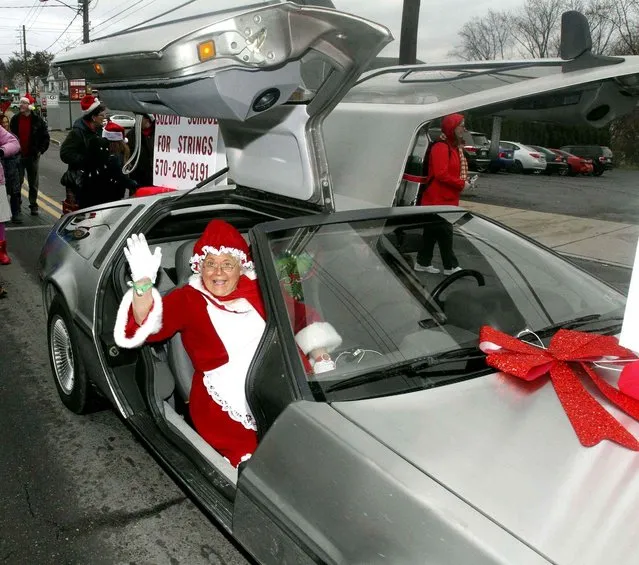 Mrs. Claus waves to the crowds along the Lions Club Santa Parade route while riding in a DeLorean in Plains Township, Pa. Saturday, November 26, 2016. (Dave Scherbenco/The Citizens' Voice via AP)