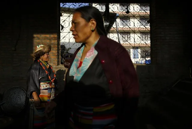 Tibetan women dressed in traditional attire works inside the kitchen to prepare food for the guests during the function organised to mark Losar or the Tibetan New Year at Tibetan Refugee Camp in Lalitpur February 19, 2015. (Photo by Navesh Chitrakar/Reuters)