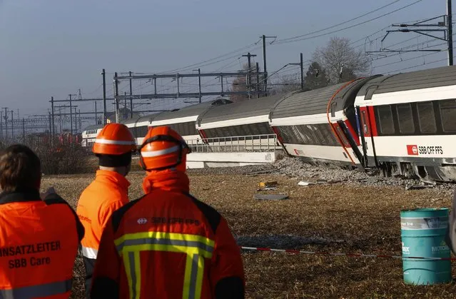 Rescue workers stand next to a derailed train after two trains collided near Rafz around 30 km (18 miles) from Zurich February 20, 2015. Two passenger trains collided in Switzerland on Friday, causing five injuries and disrupting commuter routes into Zurich, police and rail operator SBB said. (Photo by Arnd Wiegmann/Reuters)