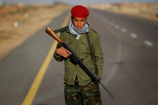 A rebel fighter guards the final checkpoint on the road from Bin Jawad towards Nawfiliyah, where forces loyal to Muammar Gaddafi have halted a rapid rebel advance some 100 km  east of Sirte in eastern Libya, March 29, 2011. (Photo by Finbarr O'Reilly/Reuters)