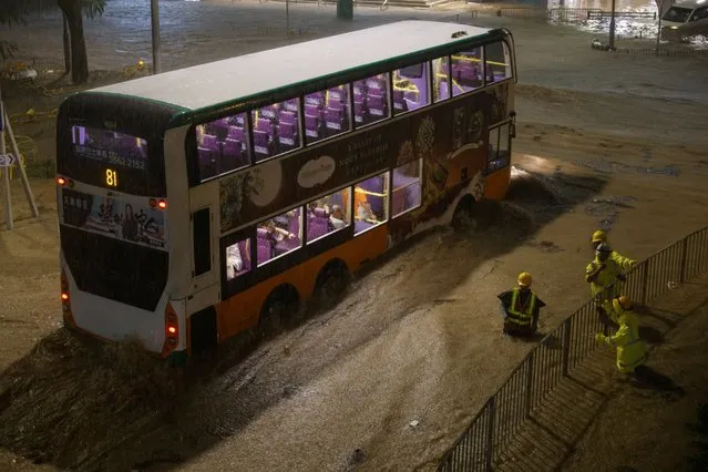 A bus drives past a flooded area during heavy rain, in Hong Kong, China on September 8, 2023. (Photo by Tyrone Siu/Reuters)