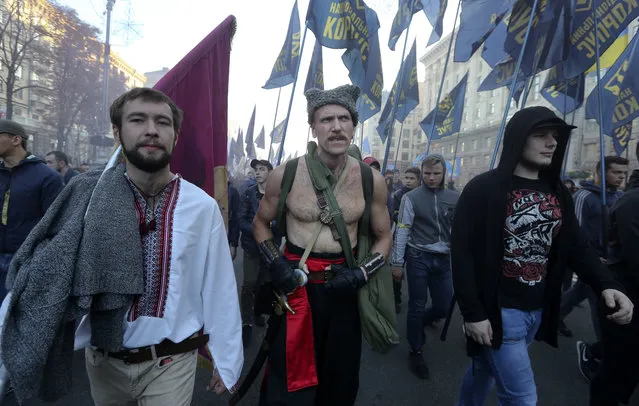 Members of the nationalist movements attend a rally marking Defender of Ukraine Day in Kiev, Ukraine, Sunday, October 14, 2018. (Photo by Efrem/LukatskyAP Photo)