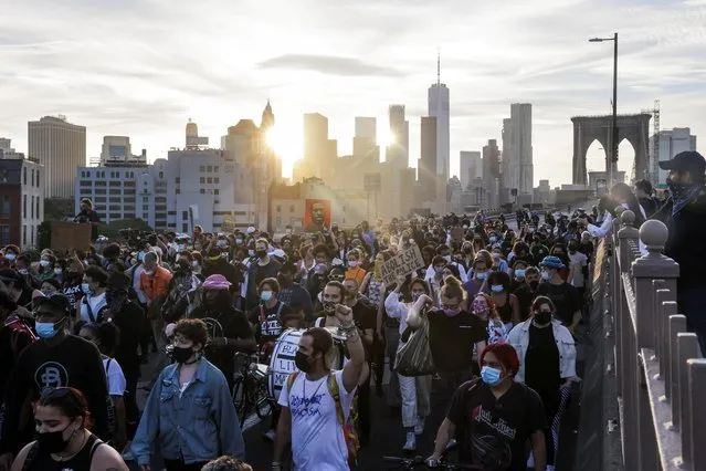 Protesters march on the Brooklyn Bridge during a demonstration on the first anniversary of the death of George Floyd, in New York City, New York, U.S., May 25, 2021. (Photo by Jeenah Moon/Reuters)