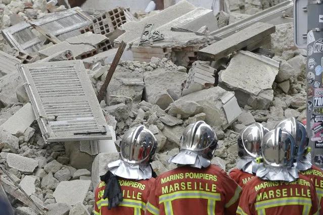 Firefighters work at the scene where a building collapsed In Marseille, southern France, Monday, November 5, 2018. A building collapsed in the southern city of Marseille on Monday, leaving a giant pile of rubble and beams. There was no immediate word on any casualties. (Photo by Claude Paris/AP Photo)