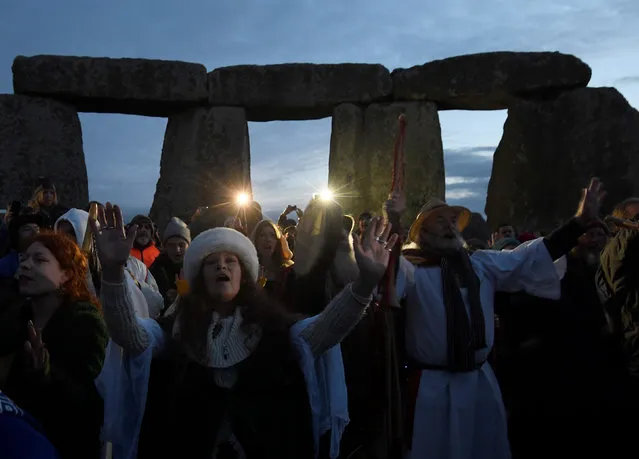 Visitors and revellers react amongst the prehistoric stones of the Stonehenge monument at dawn on Winter Solstice, the shortest day of the year, near Amesbury in south west Britain, December 21, 2016. (Photo by Toby Melville/Reuters)