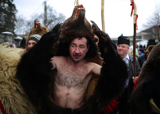 Dancers wearing costumes made of bearskins dance in the town of Comanesti, Romania December 30, 2016. (Photo by Stoyan Nenov/Reuters)