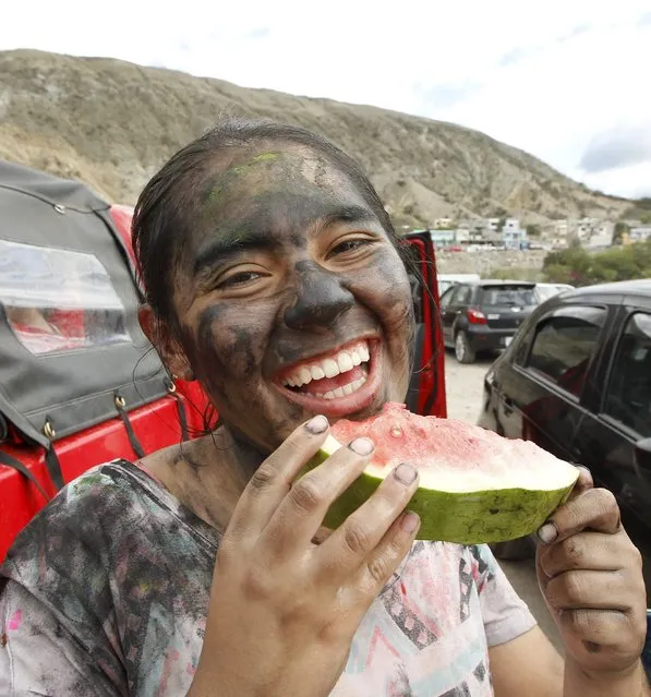 A reveller enjoys a watermelon slice at the Chota river during a carnival celebration in Coangue, February 8, 2016. (Photo by Guillermo Granja/Reuters)