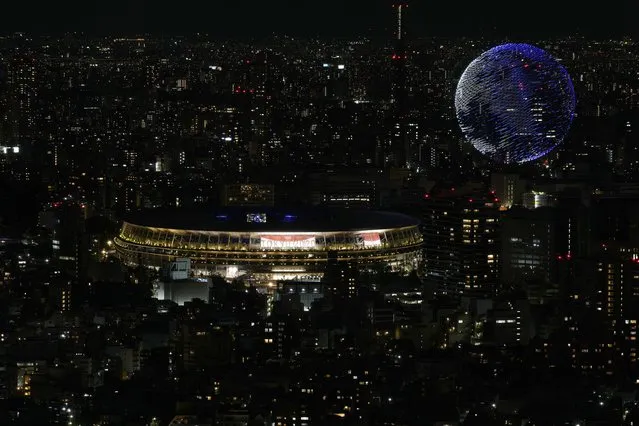 Drones flying over the National Stadium during the opening ceremony of 2020 Tokyo Olympics is seen from Shibuya Sky observation deck Friday, July 23, 2021, in Tokyo, Japan. (Photo by Eugene Hoshiko/AP Photo)