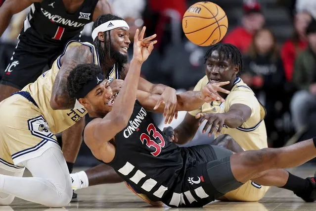 Georgia Tech guard Kowacie Reeves Jr., left, Cincinnati forward Ody Oguama (33) and Georgia Tech forward Baye Ndongo (11) compete for a loose ball during the first half of an NCAA college basketball game Wednesday, November 22, 2023, in Cincinnati. (Photo by Kareem Elgazzar/The Cincinnati Enquirer via AP Photo)