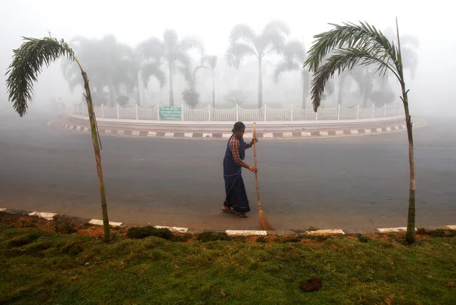 A woman sweeps a street on a foggy winter morning in Agartala, India, January 4, 2017. (Photo by Jayanta Dey/Reuters)