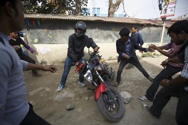 A man tries to save his motorcycle after protesters set it on fire during a nationwide strike, organised by the opposition alliance led by the Unified Communist Party of Nepal (Maoist) to demand the new constitution be drafted with the consensus of all political parties, in Kathmandu April 7, 2015. (Photo by Navesh Chitrakar/Reuters)