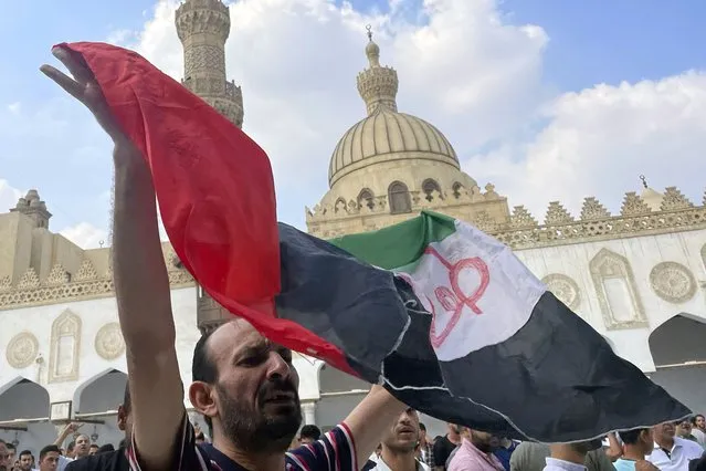 A protester waves a Palestinian flag reading “Al-Aqsa flood”, after Friday prayers at Azhar mosque, the Sunni Muslim world's premier Islamic institution, in Cairo, Egypt, Friday, October 13, 2023. (Photo by Amr Nabil/AP Photo)