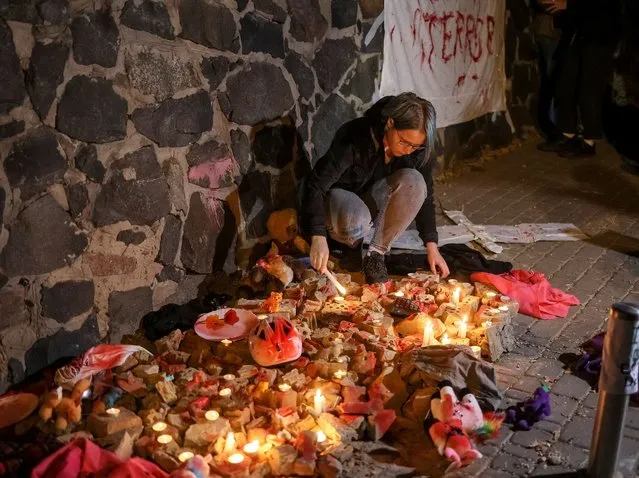 An activist lights a candle, for people killed in a Russian drone strike, during a protest against Iran allegedly supplying drones to Russia in front of the Iranian embassy after a Russian drone strike in the morning, which local authorities consider to be Iranian-made unmanned aerial vehicles (UAVs) Shahed-136, amid Russia's attack on Ukraine, in Kyiv, Ukraine on October 17, 2022. (Photo by Gleb Garanich/Reuters)