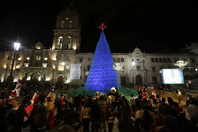 People gather at San Francisco Square in front of a Christmas tree, in La Paz, Bolivia, on December 24, 2013. (Photo by David Mercado/Reuters)