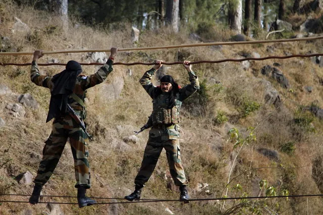 In this Tuesday, December 24, 2013 photo, Indian army soldiers cross an obstacle course, during a training session at a battle school in Rajouri, about 138 kilometers (86 miles) northwest of Jammu, India. (Photo by Channi Anand/AP Photo)