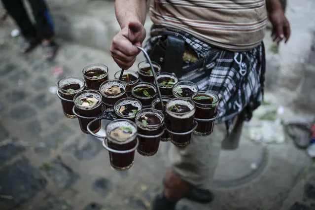 A Yemeni street vendor carries cups of tea for sale at Souq al-Melh marketplace in the old city of Sanaa, Yemen, Tuesday December 11, 2018. (Pgoto by Hani Mohammed/AP Photo)