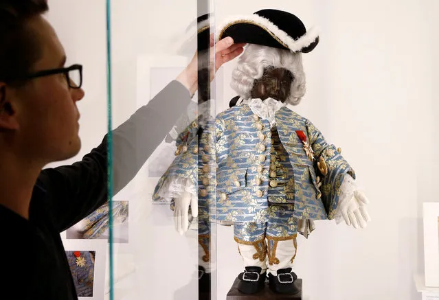 An employee adjusts a French outfit, a gift of King Louis XV in 1747, for the famous Belgian statue Manneken Pis at the museum called GardeRobe MannekenPis in central Brussels, Belgium February 2, 2017. (Photo by Francois Lenoir/Reuters)