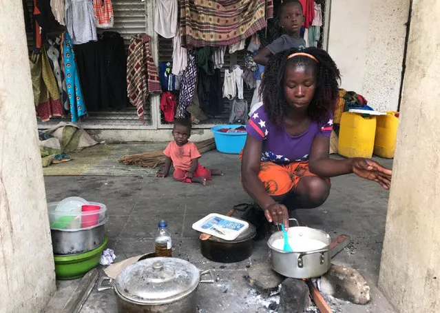 Marta Ben prepares food on a sidewalk after her home was destroyed in Beira, Mozambique, Friday March 22, 2019. There are still fears that the death toll in Mozambique could soar as floodwaters recede. The secretary-general of the International Federation of Red Cross and Red Crescent Societies says the number of deaths could be beyond the 1,000 predicted by the country's president earlier this week. (Photo by Cara Anna/AP Photo)