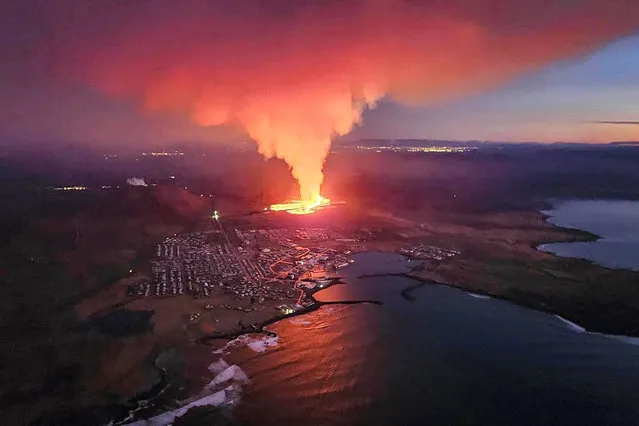 Billowing smoke and flowing lava are seen in this Icelandic Department of Civil Protection and Emergency Management, January 14, 2024, handout image during an volcanic eruption on the outskirts of the evacuated town of Grindavik, western Iceland. Seismic activity had intensified overnight and residents of Grindavik were evacuated, Icelandic public broadcaster RUV reported. This is Iceland's fifth volcanic eruption in two years, the previous one occurring on December 18, 2023 in the same region southwest of the capital Reykjavik. Iceland is home to 33 active volcano systems, the highest number in Europe. (Photo by Icelandic Department of Civil Protection and Emergency Management/AFP Photo)