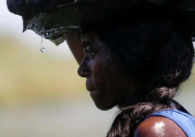 A migrant woman, seeking refuge in the U.S., walks through the Rio Grande river, border between Ciudad Acuna, Mexico and Del Rio, Texas, U.S., after crossing into Mexico for food, in Ciudad Acuna, Mexico on September 20, 2021. (Photo by Daniel Becerril/Reuters)