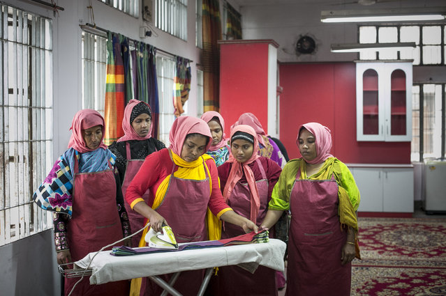 Women practice using an iron at the Sheikh Fazilatunnesa Mujib Mohila Technical Training Center on March 14, 2016 in Dhaka, Bangladesh. The training center provides potential migrant workers with the skills they need to earn a living overseas. Bangladesh received $15.31 billion in remittances from an estimated 9.4 million citizens working overseas in the fiscal year that ended in June 2015. Rights groups such as Human Rights Watch have published reports documenting how migrant domestic workers are particularly vulnerable to abuse. (Photo by Allison Joyce/Getty Images)