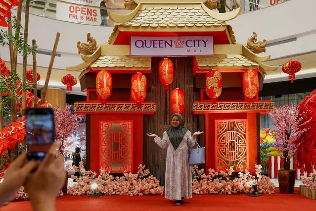 A woman poses for pictures near decorations welcoming the Lunar New Year at a shopping mall in Semarang, Central Java province, Indonesia, on February 8, 2024. (Photo by Willy Kurniawan/Reuters)
