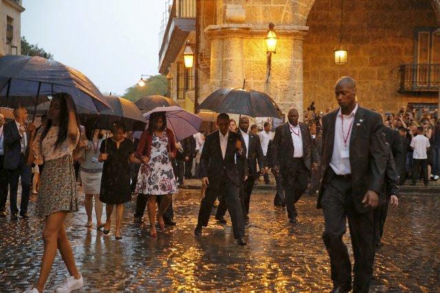 U.S. President Barack Obama steps over a puddle while touring Old Havana with his family, in Havana March 20, 2016. (Photo by Carlos Barria/Reuters)