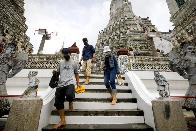 Tourists walk inside the Temple of Dawn (Wat Arun) in Bangkok, Thailand, 08 November 2021. Thailand reopened the country, allowing fully vaccinated foreign tourists from low-risk of coronavirus pandemic countries to visit the kingdom without undergoing quarantine requirements. The government aims to boost the tourism industry and its economy after being devastated by the prolonged pandemic. (Photo by Diego Azubel/EPA/EFE)