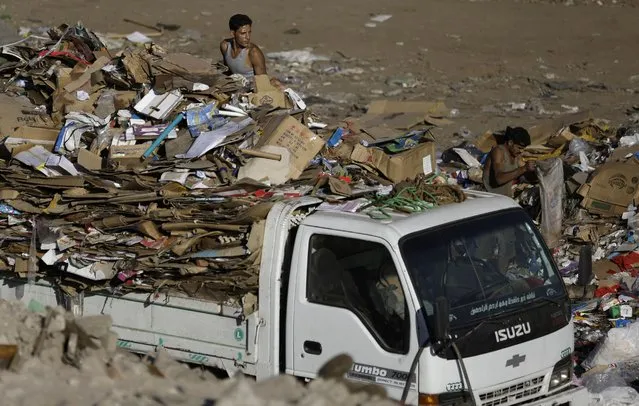 In  this October 23, 2014 file photo, Egyptian garbage collectors carry paper on a truck as they sift through garbage in Cairo, Egypt. Egypt's justice minister, Mahfouz Saber, raised an uproar after he said in a Sunday, May 10, 2015, television interview that the children of sanitation workers are too lowly to become judges, saying those who join the judiciary must hail from “appropriate” backgrounds. (Photo by Hassan Ammar/AP Photo)