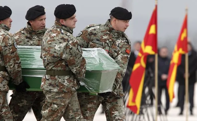 Army soldiers carry a coffin containing the remains of a passenger killed in a bus crash in Bulgaria ten days ago, during the repatriation ceremony at Skopje Airport, North Macedonia, Friday, December 3, 2021. Two Bulgarian military planes have landed Friday at North Macedonia's main airport carrying remains of 45 people killed in bus crash in Bulgaria ten days ago to be handed to their families for burials. (Photo by Boris Grdanoski/AP Photo)