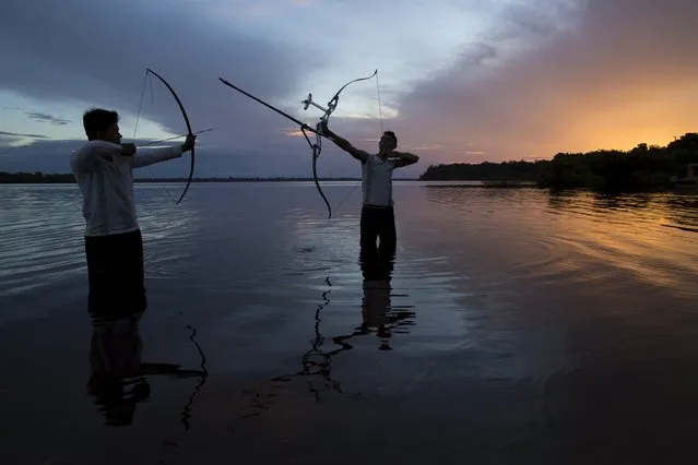 Kambeba Indian, Dream Braga (R), 18, and his friend Nelson Varge da Silva, pose for pictures at sunset on the banks of the Negro river at the village Tres Unidos, Amazon state May 9, 2015. (Photo by Bruno Kelly/Reuters)