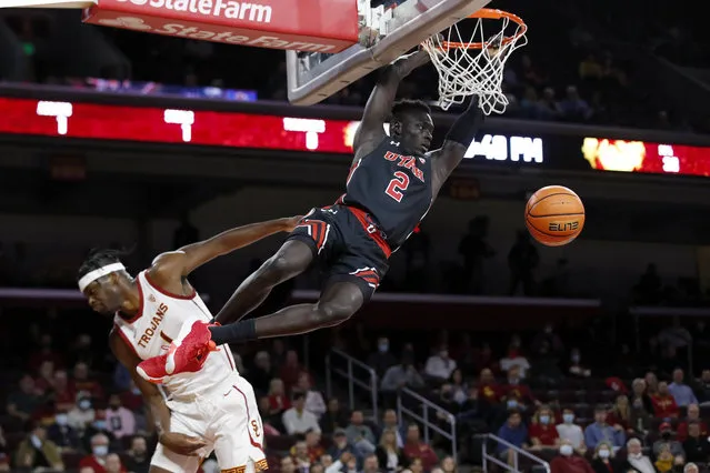 Utah guard Both Gach, right, dunks against Southern California forward Chevez Goodwin during the first half of an NCAA college basketball game in Los Angeles, Wednesday, December 1, 2021. (Photo by Alex Gallardo/AP Photo)