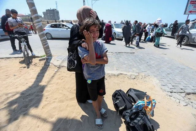 A displaced Palestinian boy cries while standing with his sister as they wait for their parents, who attempt to return to their home in north Gaza through an Israeli checkpoint, in the central Gaza Strip, on April 15, 2024. (Photo by Ramadan Abed/Reuters)