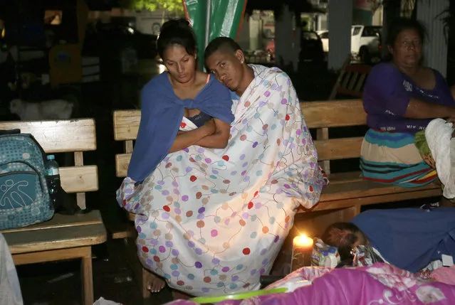 Residents sit covered with blankets outside thier houses in the Pacific coastal town of Pedernales, Ecuador, Sunday, April 17, 2016. (Photo by Dolores Ochoa/AP Photo)