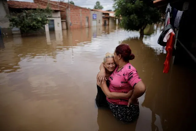 Ilzete is embraced by her daughter Joelma in front of a flooded house during floods caused by heavy rain in Imperatriz, Maranhao state, Brazil on January 6, 2022. (Photo by Ueslei Marcelino/Reuters)
